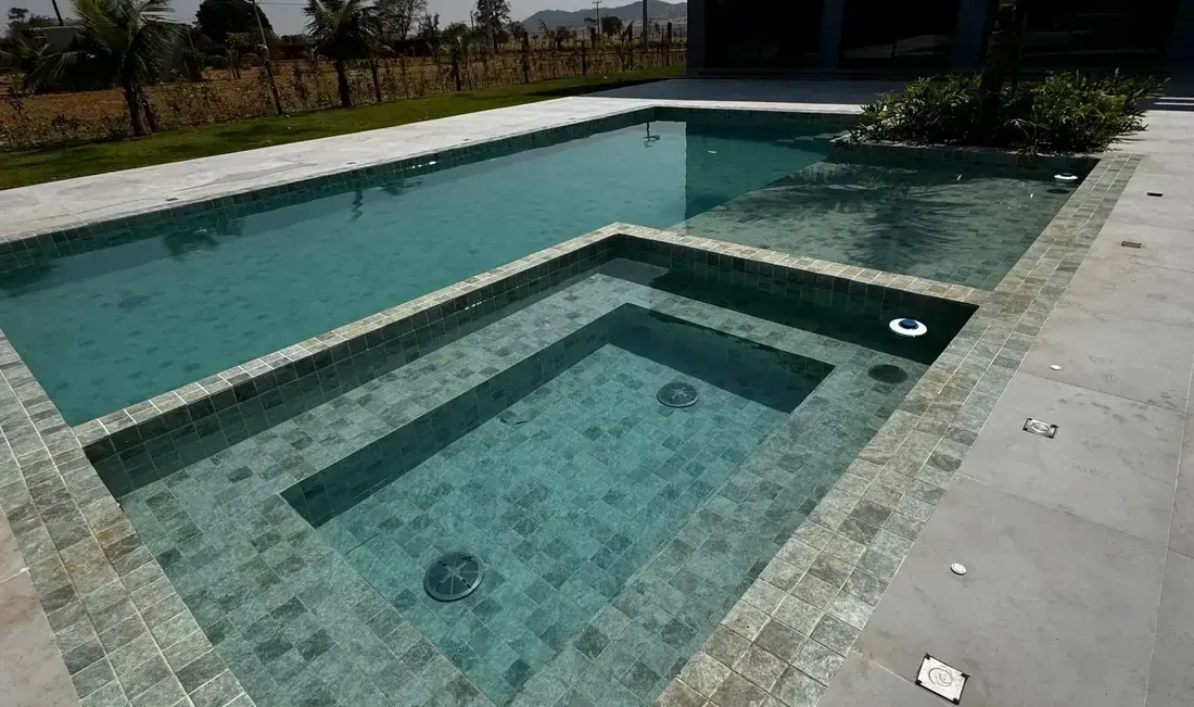 Piscina com prainha e borda em pedra de uma casa de alto padrão em Bela Vista de Goiás, etapa final do prazo para construir a obra