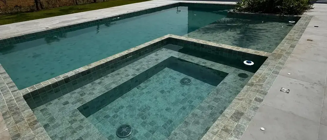 Piscina com prainha e borda em pedra de uma casa de alto padrão em Bela Vista de Goiás, etapa final do prazo para construir a obra