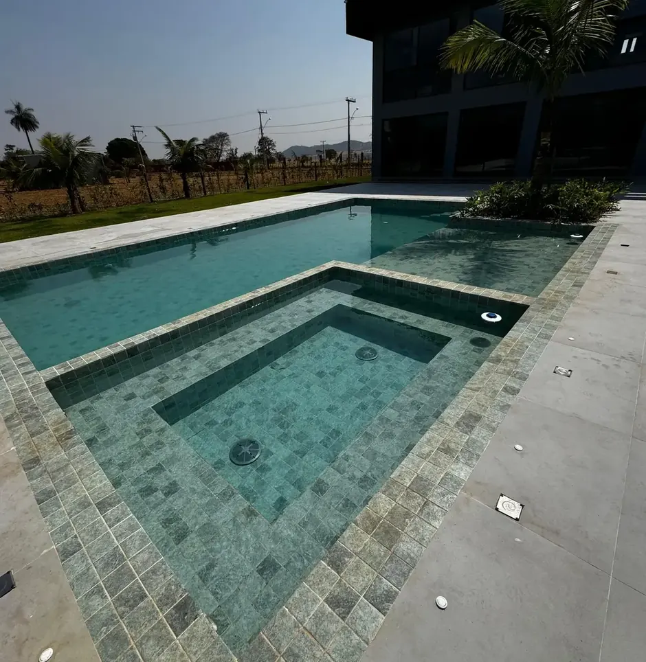 Piscina com prainha e borda em pedra da Casa Aroeiras