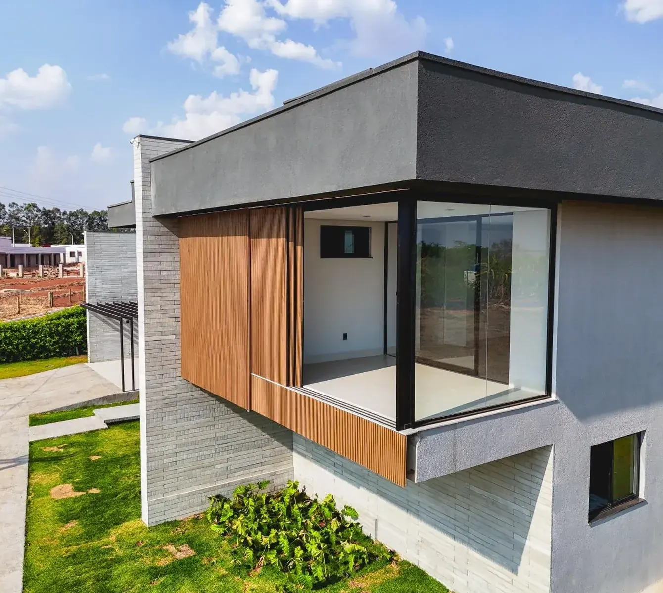 Fachada da Casa Jacarandá em Aparecida de Goiânia com volume em madeira