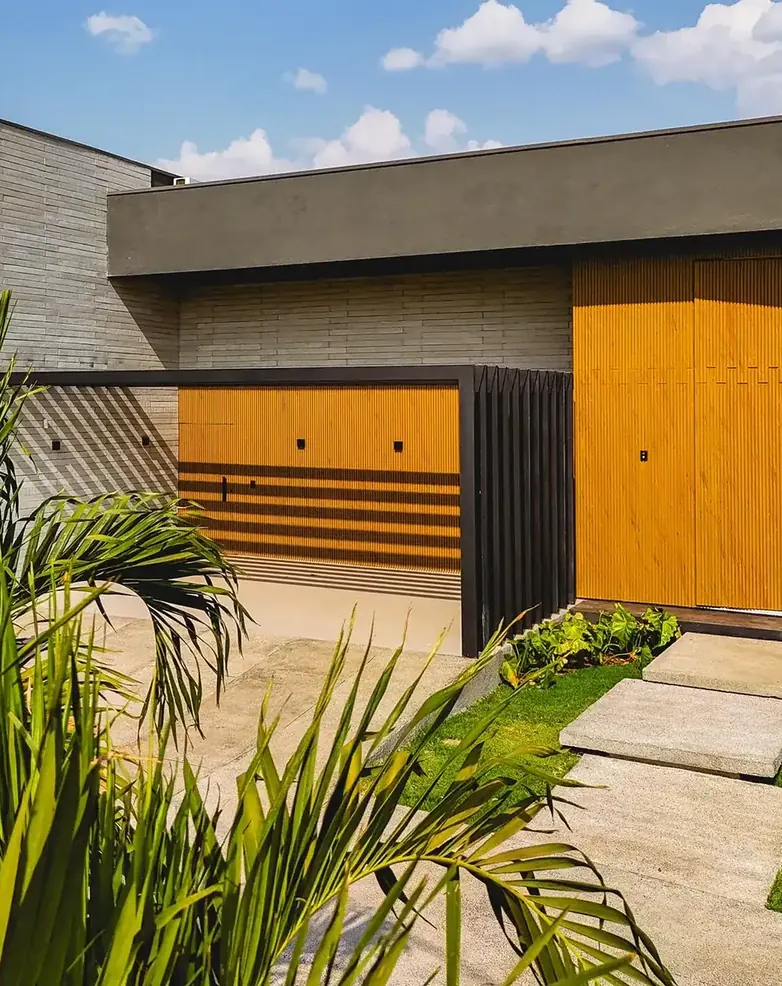 Casa de alto padrão com fachada em madeira e pedra, obra da GEFORTE, empresa de engenharia em Goiânia